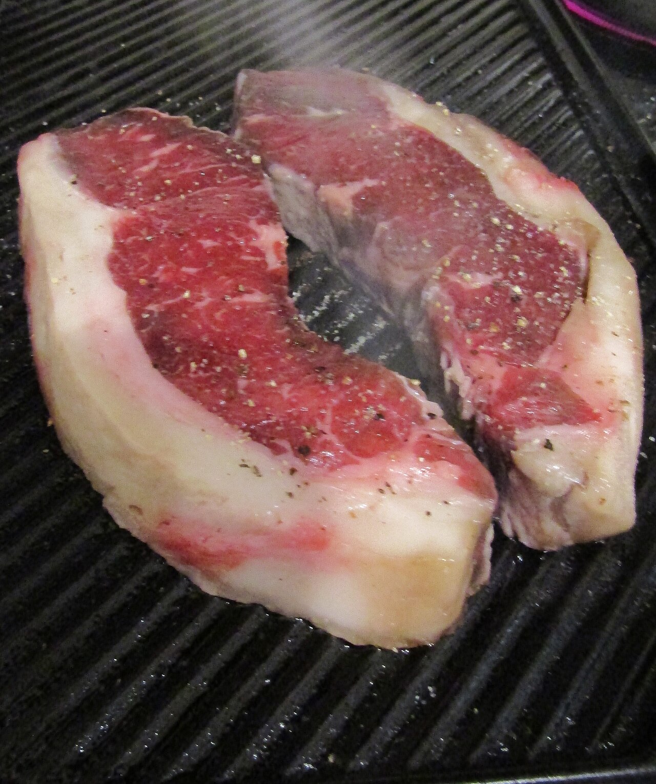Filetes cocinándose sobre una placa acanalada